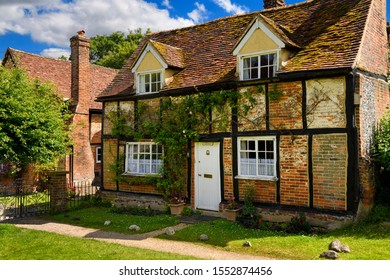 Red brick and roof tile tudor house Church Cottage rectory at St Mary the Virgin in Turville village, Buckinghamshire, England - June 22, 2019
