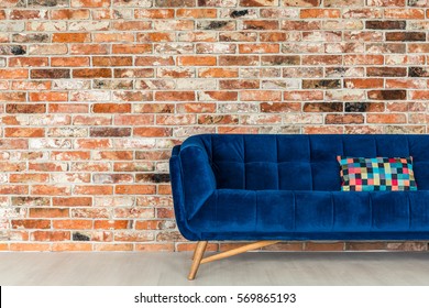 Red Brick Wall And Blue Sofa With Patchwork Pillow