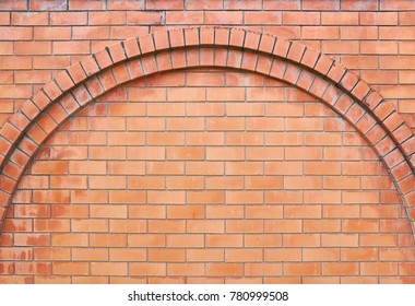 Red brick wall. Empty background of a rounded brick masonry arch. The surface of the cleaned brickwork texture.