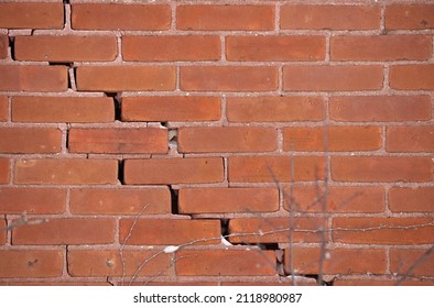 Red Brick Wall With Large Crack And Crumbling Mortar