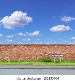 Red Brick Wall With A Main Street Sign And Sidewalk