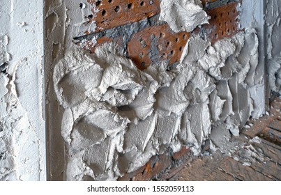 Red Brick Wall With Stucco Beacons And Scattered, But Not Aligned Stucco Mortar

