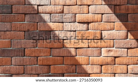 Red brick wall texture background with diagonal sunlight and shadow.