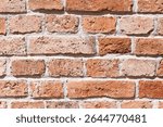 Red brick wall texture. Rustic masonry background with cement joints. Aged construction detail with natural imperfections. Traditional building material for architectural and design projects.