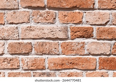 Red brick wall texture. Rustic masonry background with cement joints. Aged construction detail with natural imperfections. Traditional building material for architectural and design projects.