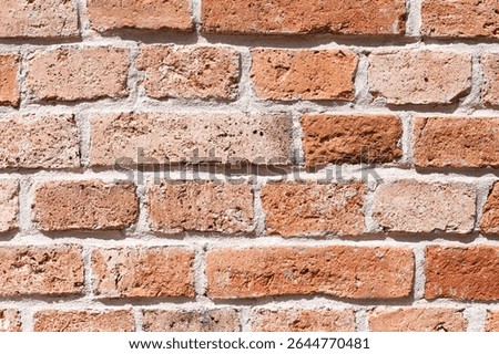 Red brick wall texture. Rustic masonry background with cement joints. Aged construction detail with natural imperfections. Traditional building material for architectural and design projects.