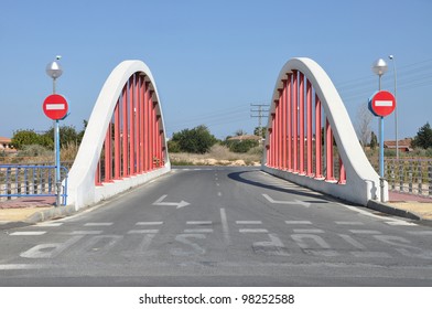 Red Bridge With Wrong Way And Stop Sign Painted On Blacktop Pavement