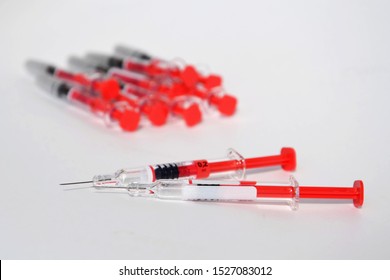 Red Bright Syringe Lying On White Background, Diabetes, Blood Thinning Or Vaccination Concept