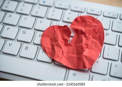 Red Broken Heart Paper On White Keyboard Computer Background. Online Internet Romance Scam Or Swindler In Website Application Dating Concept. Love Is Bait Or Victim.