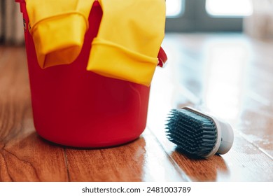 Red bucket, yellow gloves, brush, water bucket, cleaning supplies on the floor - Powered by Shutterstock