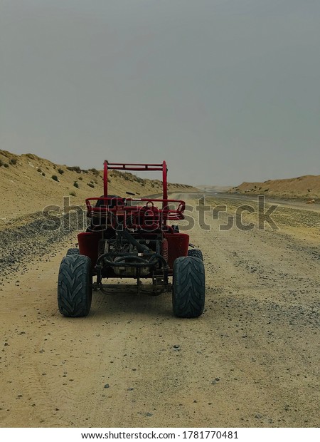 red buggy car in desert\
sand road 
