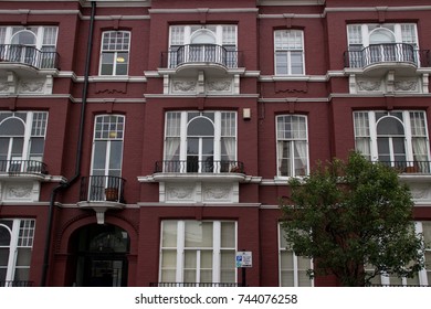 Red building with trees in front..