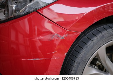 Red Bumper Car Scratched With Deep Damage To The Paint, Accident Concept.