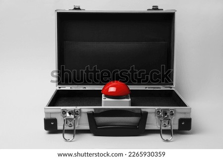 Red button of nuclear weapon in suitcase on white background. War concept