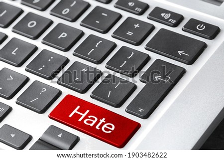 Red button with text Hate on computer keyboard, closeup