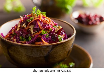 Red cabbage, carrot, apple salad with nuts and cranberry. Coleslaw for autumn or winter season.