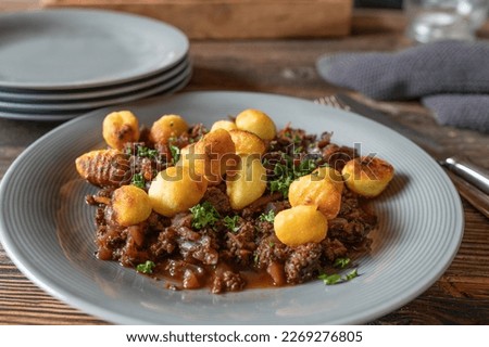 Red cabbage with ground beef stew. Served with pan fried gnocchi on a plate