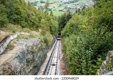 Red Cable Car Driving Downhill From Harder Kulm, Top Of Interlaken. Transportation, Tourism.