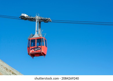 A red cable car on its way from Skalnate pleso to Lomnicky peak. Red gondola moving up to Lomnica peak in High Tatras Mountains. Slovakia.