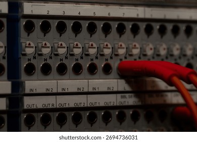 Red Cable Connected to Audio Interface Panel with Multiple Input and Output Ports