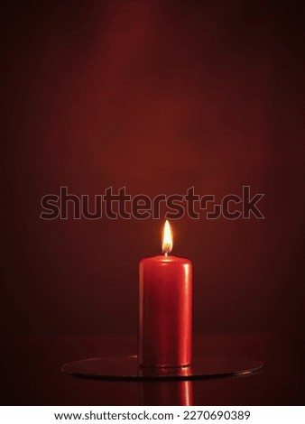 Red candle on a red background