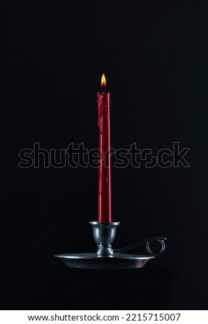 Red candle on black background