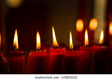 Red Candles Burning Candlelight Illuminated in the Night with Bokeh Background