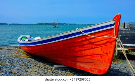 Red canoe moored on the rock beach in Boston, Massachusetts, a tranquil seascape in New England, USA - Powered by Shutterstock