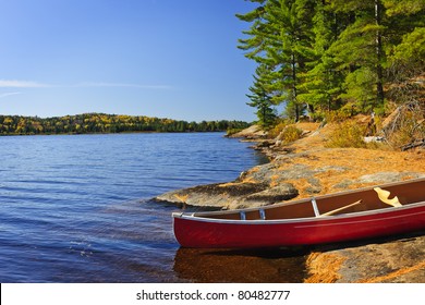 Red Canoe On Rocky Shore Of Lake Of Two Rivers, Ontario, Canada