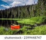 A red canoe on shore of Scott Lake, located in the Cascade Mountains near the summit of the McKenzie Pass, Oregon.