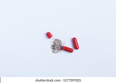 red capsule powder white background
