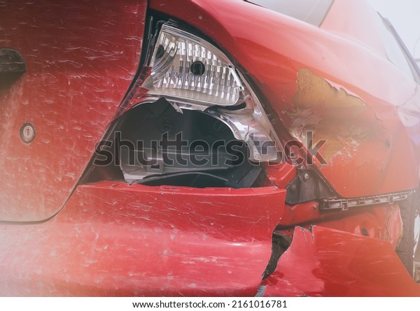 A red car after an accident, a broken\
bumper, a wing and a rear brake light in close-up. Car accident -\
accident and insurance. Car accident\
close-up.