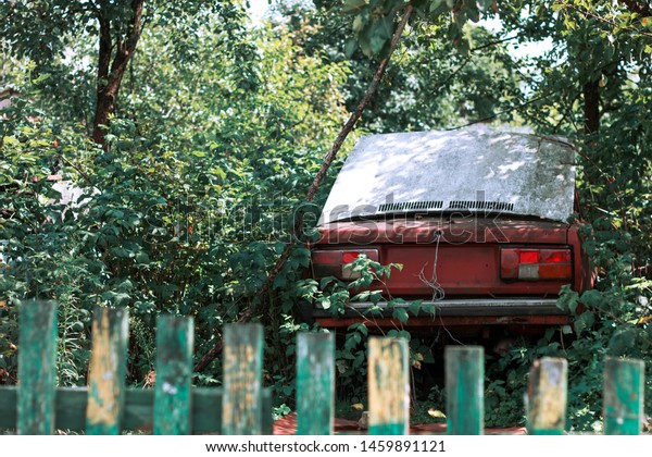red car behind the green\
fence