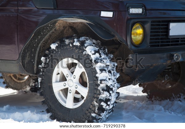 red car with big wheels\
in the snow