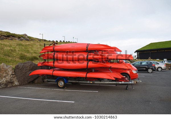 red car with red boats at\
parking