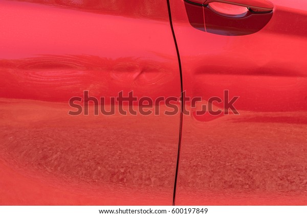 Red car\
body damage, dented car doors after\
accident.