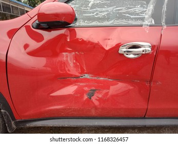 Red car dent in a door in the street after a broken accident - Powered by Shutterstock