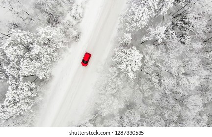 Red Car Driving On A Snow Covered Iced Road In Winter Time