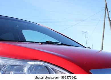 red car front view. Elements of car bright red against the sky on a winter sunny day. Photo of car part, Background image, Car front end.