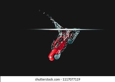 A Red Car Hits The Water, Black Background. Toy Car, Vehicle Dropping In Water And Creating A Splash. Toy Thrown Into The Water, Road Accident, The Effect Of The Car's Fall.