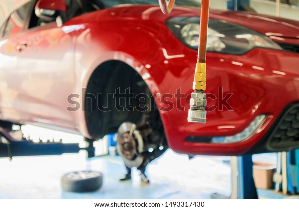 Red car lift at maintenance station\
in automotive service center blur abstract\
background