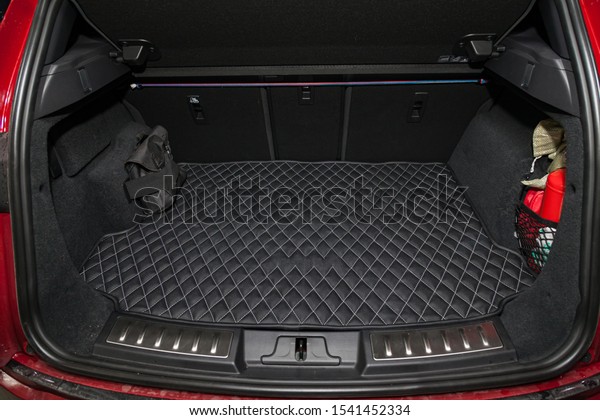Red Car luggage space\
in the body of the SUV hatchback with open trunk and leather floor\
mat interior after washing and dry cleaning. Auto service industry.\
Travel concept.