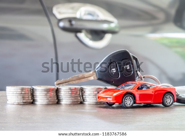 red car model and key on stacks of coin, fixed\
rate for car loan, or Saving money for car,  trade car for cash,\
finance concept