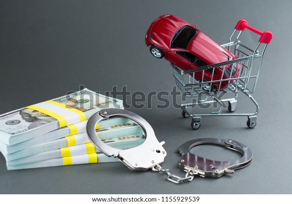  Red car  money\
handcuffs. shopping for vehicles fraud car sale scam  breaking the\
law car dealer concept.