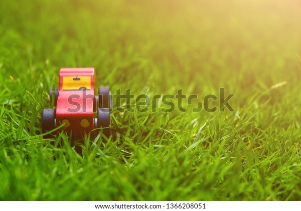 Red car or moving forward\
or build the power with green grass with soft light. Object and\
background.