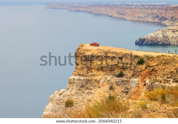 Red car on a high\
cliff