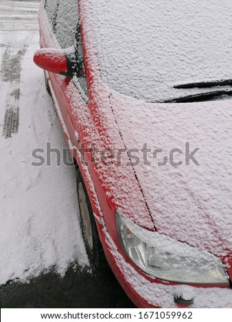 Red car on a snowy morning.