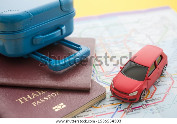 Red car rental, suitcase and passports on map\
background. Travel insurance covers loss suitcase, flight delays,\
cancellations, evacuations and medical expenses. Travel insurance\
business concept.