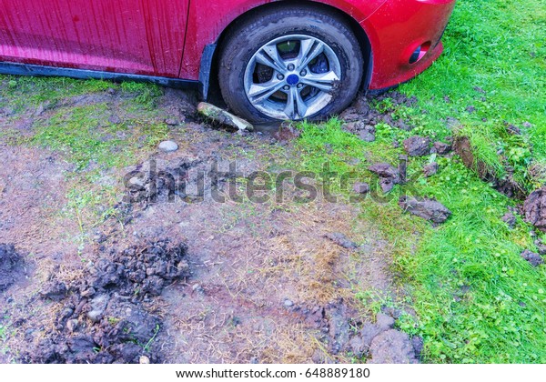 Red\
car stuck in the mud , soft land after heavy raining\
