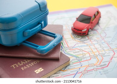 Red car, suitcase and passport on map background. Travel insurance covers loss suitcase, flight delays, cancellations, evacuations and medical expenses. Travel insurance, planning concept.
